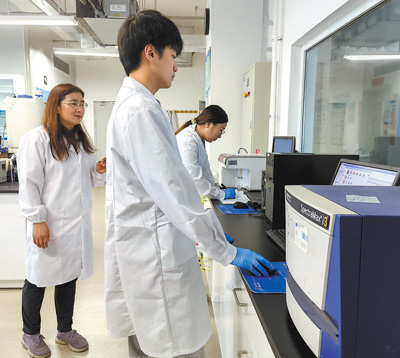 楊延蓮（左一）和團隊成員在實驗室進行微球捕獲的外泌體的流式熒光檢測。國家納米科學中心供圖